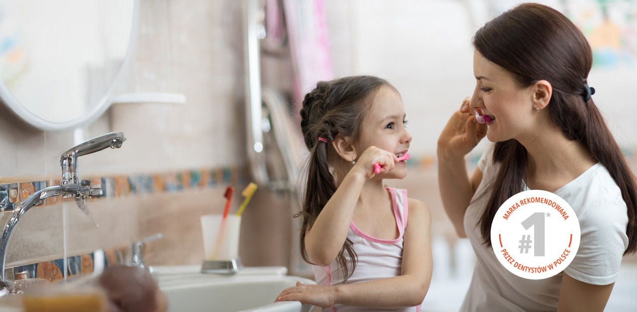 family brushing their teeth with recomended brand symbol on the right