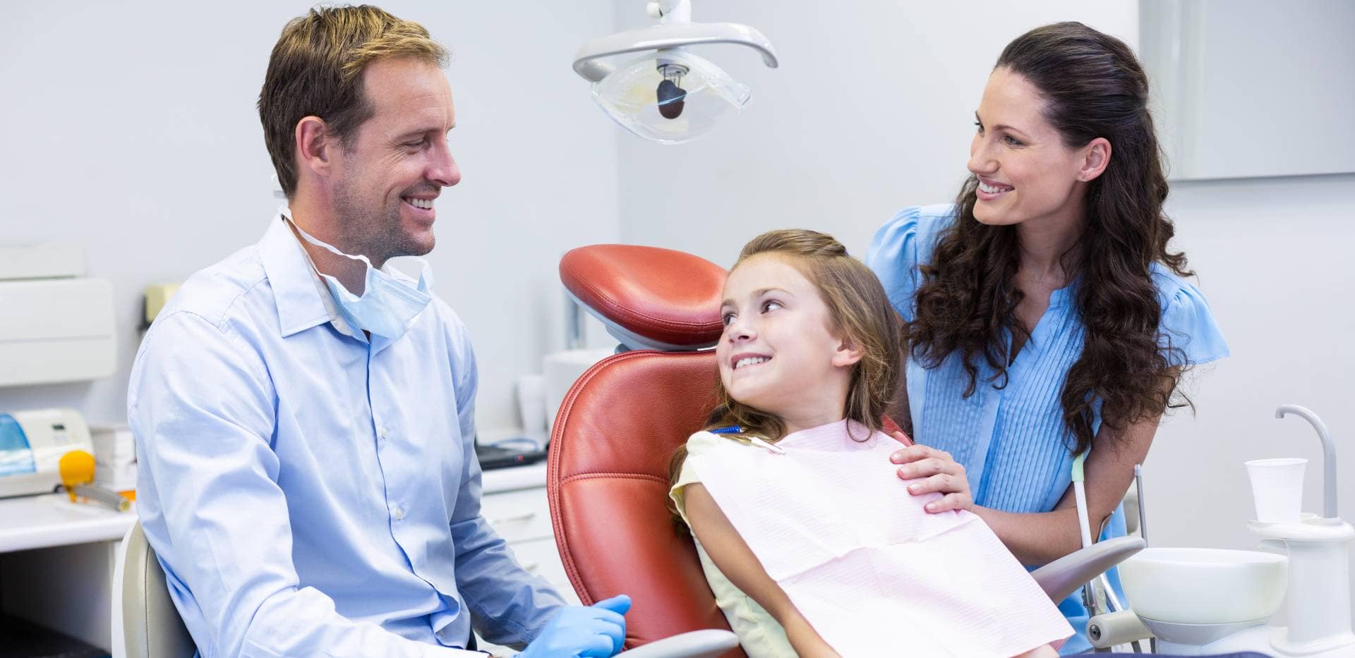 Dentysta, dziecko i rodzic w gabinecie stomatologicznym